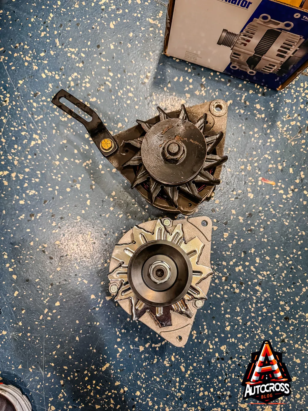 Old and New alternator sitting on the garage floor